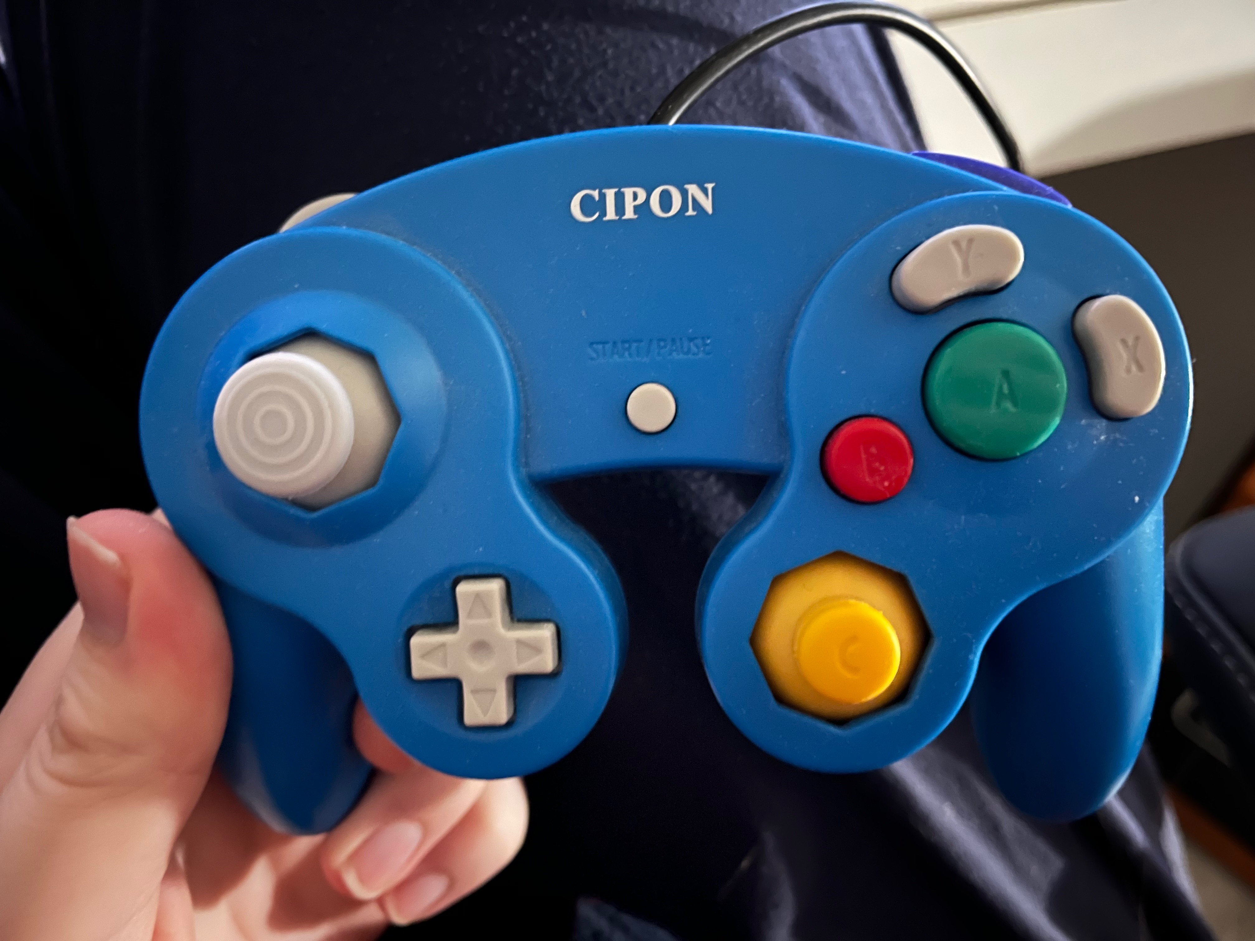 A photo of me holding a Cipon-branded Gamecube controller in my lap.